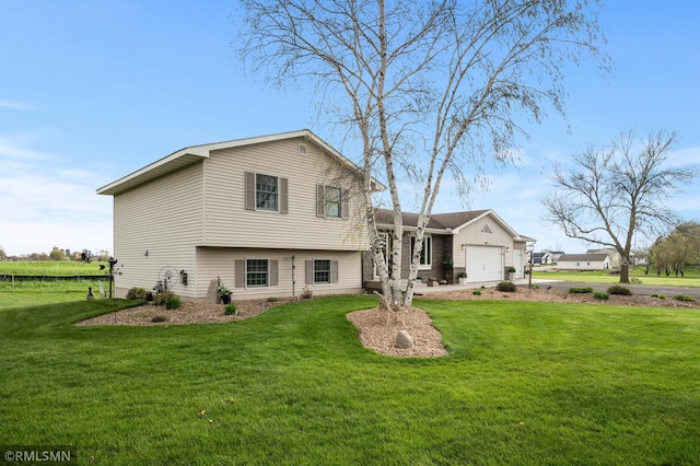 back of property featuring a garage and a lawn