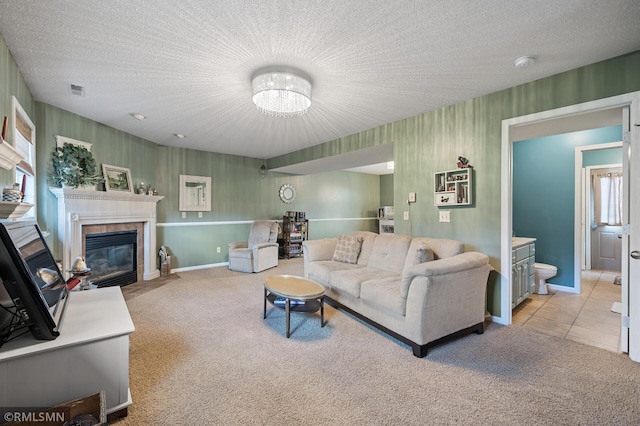 living room featuring light carpet, a textured ceiling, a fireplace with flush hearth, and wallpapered walls