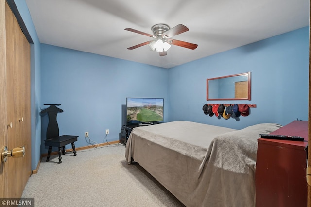 carpeted bedroom with a ceiling fan, a closet, and baseboards