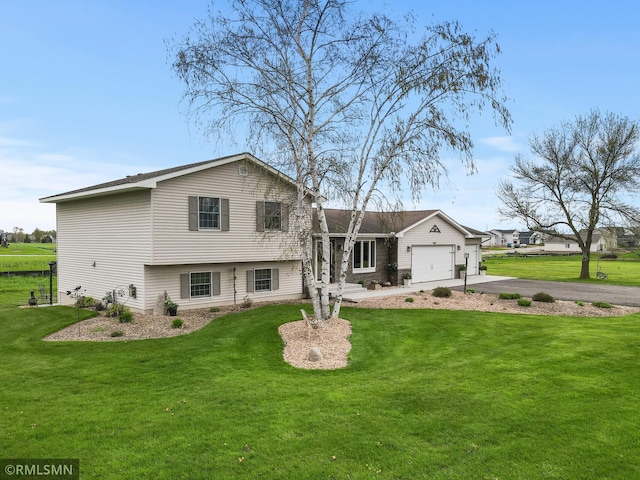 split level home with an attached garage, a front lawn, and aphalt driveway