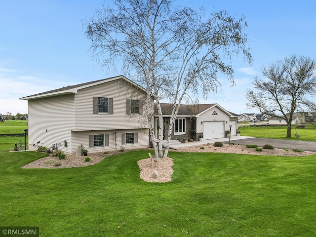 split level home featuring driveway, an attached garage, and a front lawn