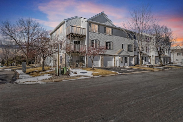 view of property featuring an attached garage, cooling unit, and driveway