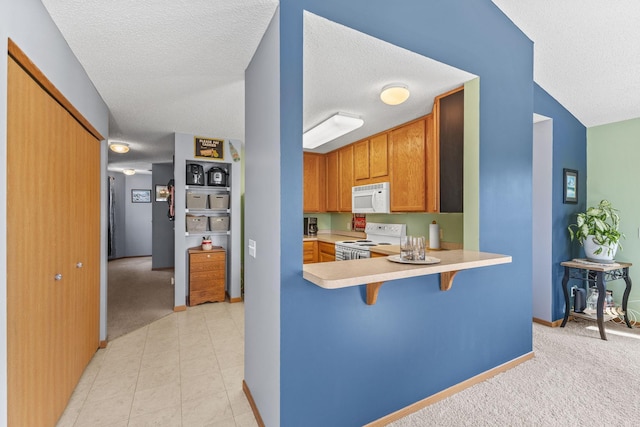 kitchen with a breakfast bar, white appliances, light countertops, and light carpet