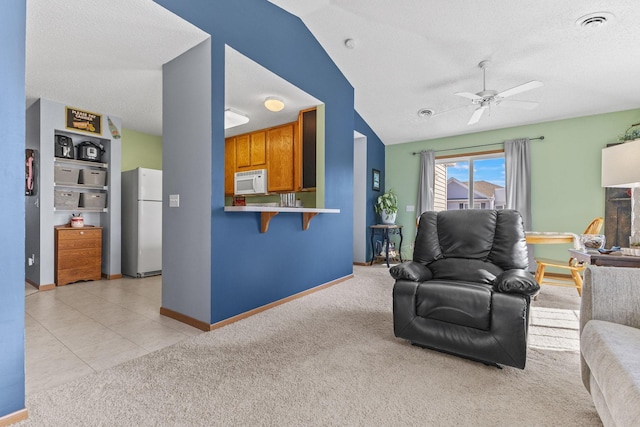 living area featuring visible vents, light carpet, a textured ceiling, and ceiling fan