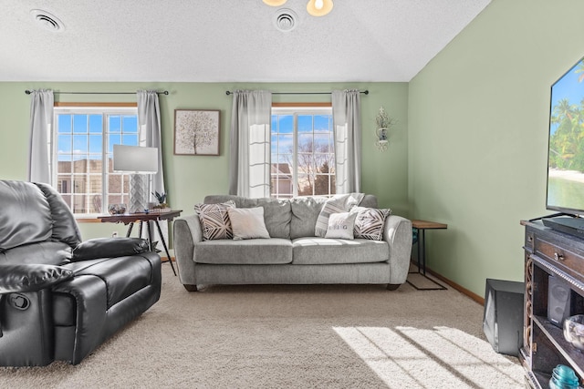 living area with baseboards, carpet flooring, a textured ceiling, and visible vents