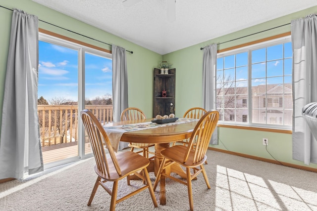 dining area featuring carpet flooring, a textured ceiling, and baseboards