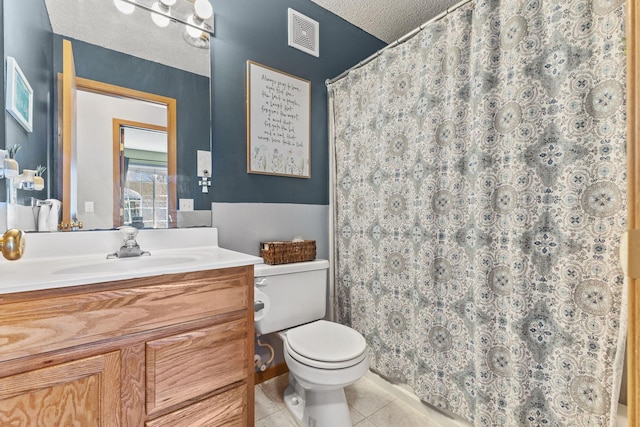 bathroom featuring vanity, visible vents, a textured ceiling, tile patterned floors, and toilet