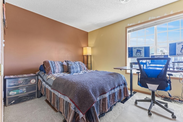 bedroom featuring multiple windows, a textured ceiling, baseboards, and carpet floors