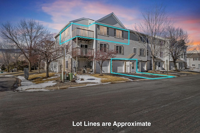 townhome / multi-family property featuring a balcony, an attached garage, and driveway