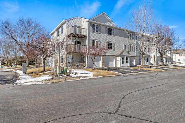 view of property featuring a garage, a residential view, and driveway