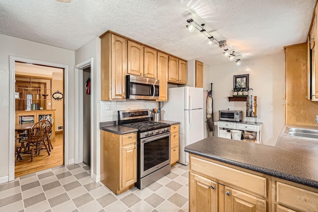 kitchen featuring a sink, tasteful backsplash, light floors, and appliances with stainless steel finishes