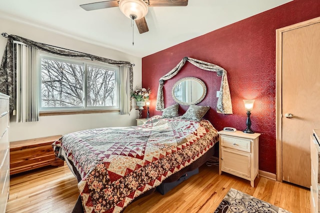 bedroom featuring baseboards, light wood-style floors, ceiling fan, and wallpapered walls