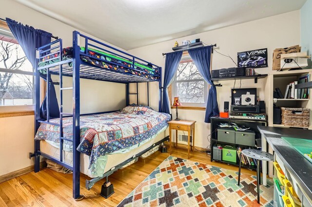 bedroom with visible vents, baseboards, and wood finished floors