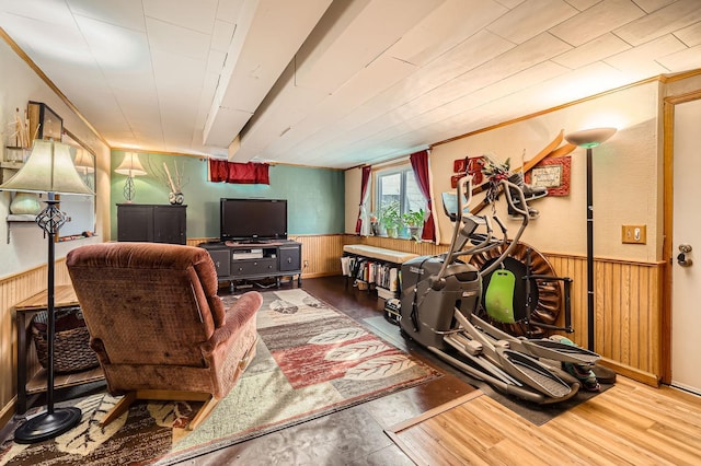 exercise room with wood finished floors, wood walls, and wainscoting