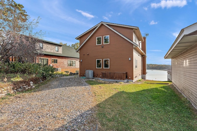 back of property featuring a water view, a yard, and central AC unit