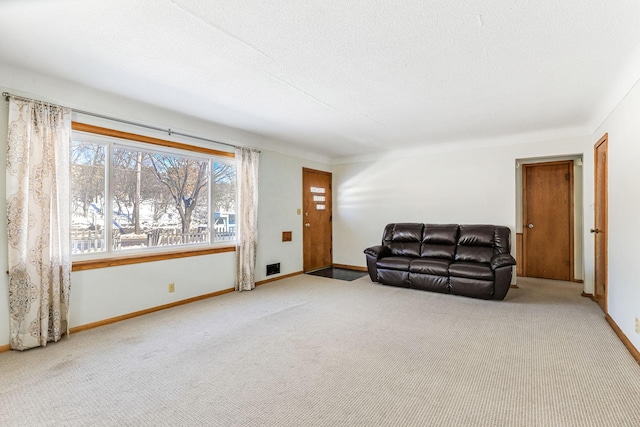 living area with a textured ceiling, baseboards, and carpet