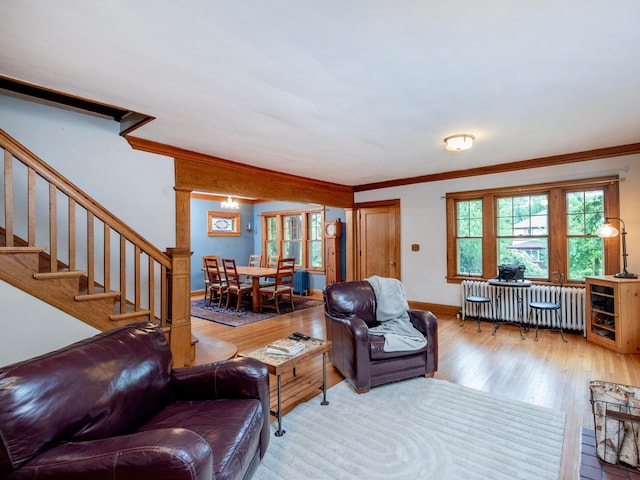 1286 Fairmount Ave, Saint Paul, MN 55105 - living room featuring radiator heating unit, ornamental molding, stairway, wood finished floors, and baseboards