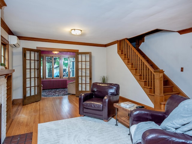 1286 Fairmount Ave, Saint Paul, MN 55105 - living area with radiator, a wall mounted air conditioner, stairway, french doors, and wood finished floors