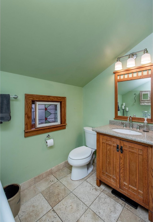 1286 Fairmount Ave, Saint Paul, MN 55105 - bathroom featuring toilet, baseboards, vanity, and vaulted ceiling