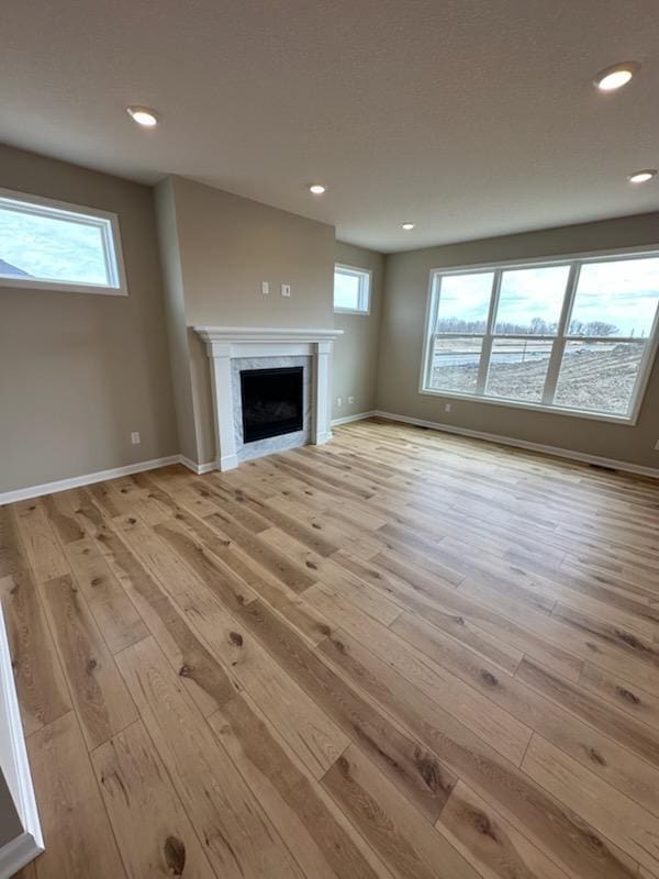 14403 107th Pl N, Maple Grove, MN 55369 - unfurnished living room with baseboards, light wood-type flooring, a fireplace, and recessed lighting