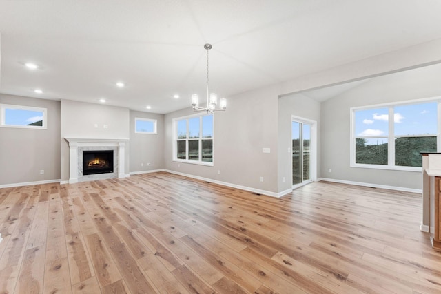 14403 107th Pl N, Maple Grove, MN 55369 - unfurnished living room with light wood-style floors, a warm lit fireplace, recessed lighting, and a chandelier