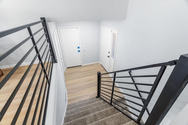 staircase with baseboards and wood finished floors