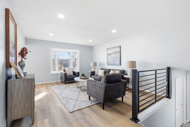 living room featuring baseboards, light wood-style flooring, and recessed lighting