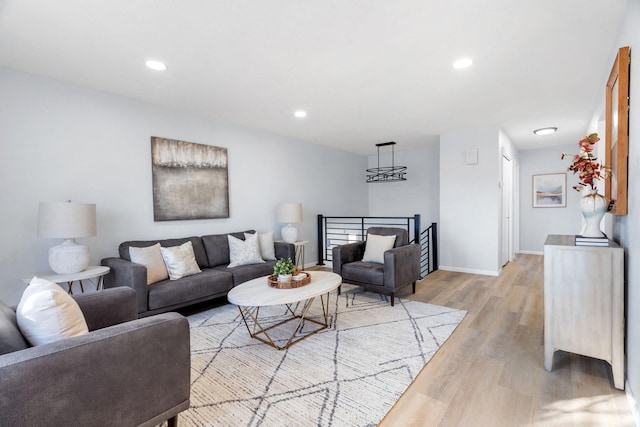 living room with baseboards, recessed lighting, and light wood-style floors