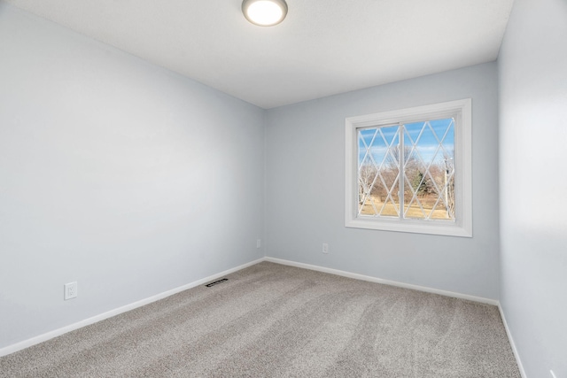 spare room with baseboards, visible vents, and carpet flooring