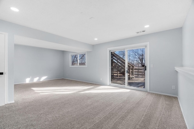 carpeted empty room with baseboards, visible vents, and recessed lighting