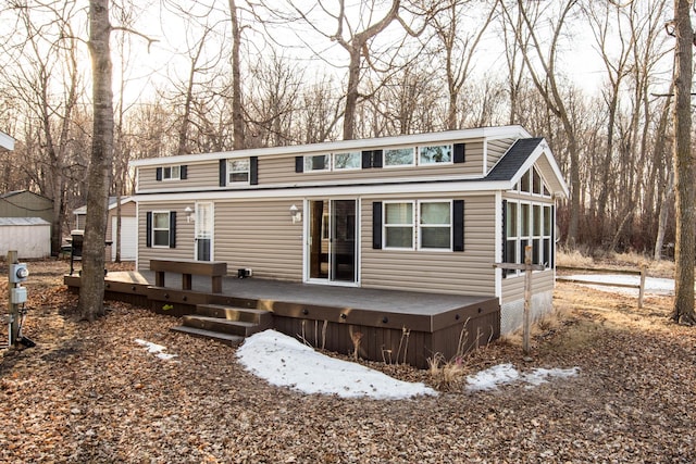 view of front of house with a wooden deck and roof with shingles