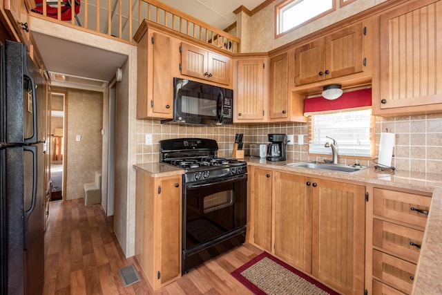 kitchen with visible vents, black appliances, light countertops, and a sink