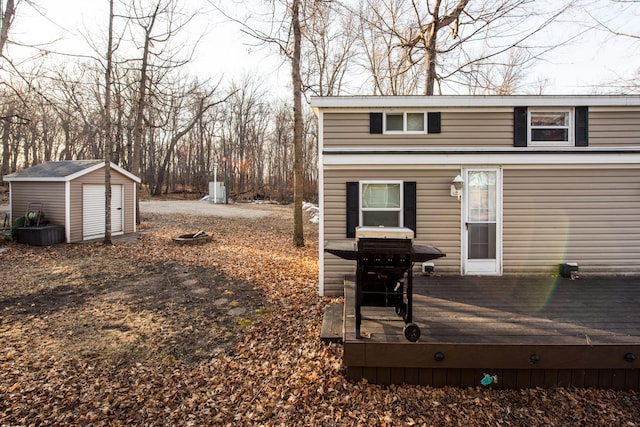 back of property featuring a deck, an outdoor structure, and a shed