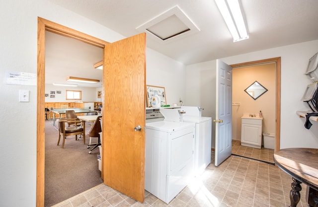 clothes washing area with attic access, separate washer and dryer, light colored carpet, and laundry area