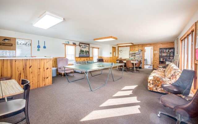 game room with bar, wood walls, and carpet flooring