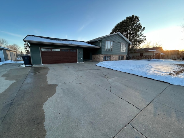 tri-level home with an attached garage and concrete driveway