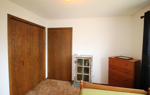 bedroom featuring a closet, a textured ceiling, and carpet