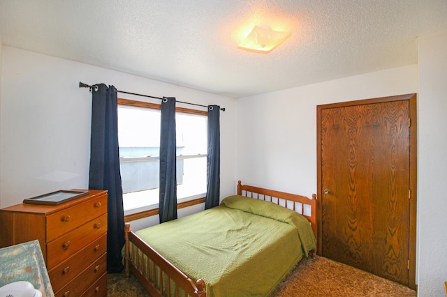 bedroom with a textured ceiling and carpet
