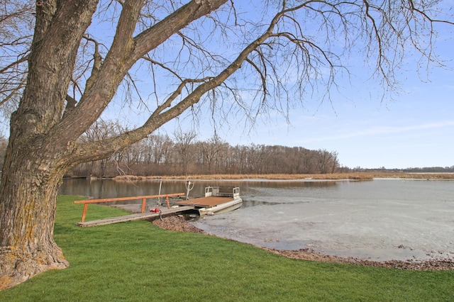 view of dock with a yard and a water view