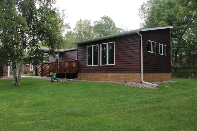 exterior space with a deck and a lawn