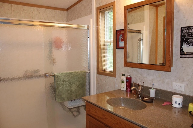 full bath with wallpapered walls, a shower stall, and vanity