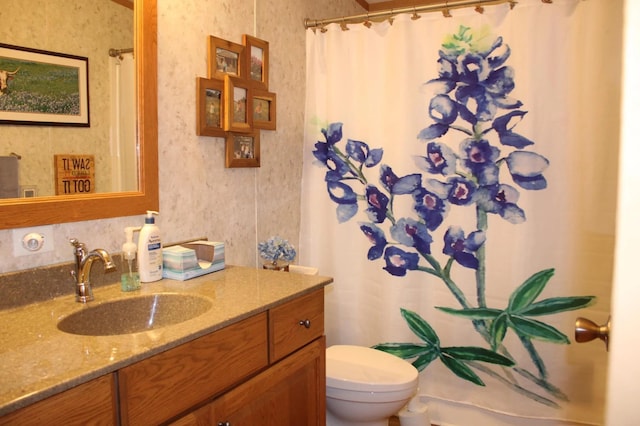 full bathroom featuring a shower with shower curtain, vanity, and toilet