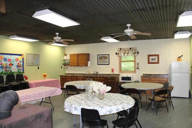 dining area with concrete floors and a ceiling fan