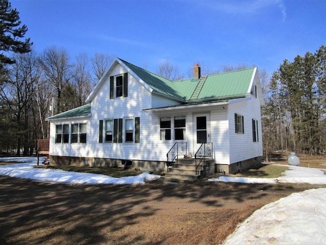 view of front of house with a chimney and metal roof