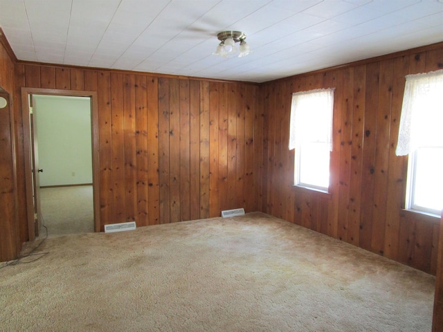 spare room featuring a healthy amount of sunlight, visible vents, and carpet flooring