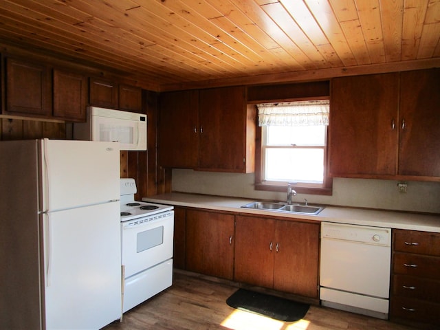 kitchen featuring white appliances, wooden ceiling, wood finished floors, light countertops, and a sink