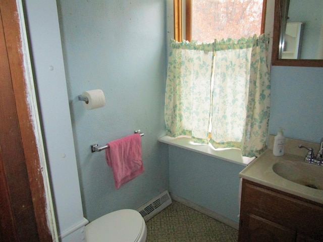 half bath featuring baseboards, visible vents, vanity, and toilet