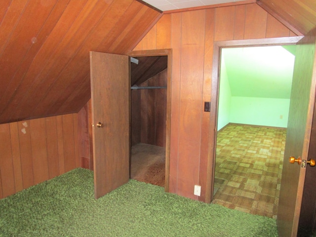 additional living space with vaulted ceiling and wooden walls