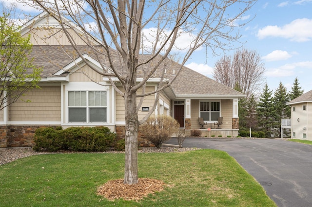 3595 Lemieux Cir, Eagan, MN 55122 - view of front of home with stone siding, roof with shingles, driveway, a front yard, and a porch