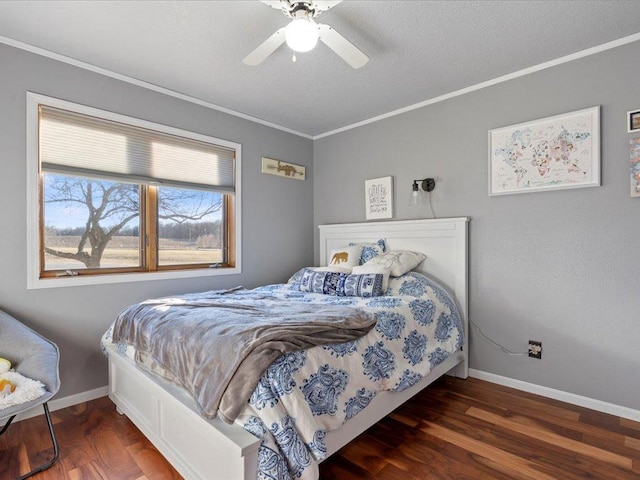 bedroom featuring baseboards, wood finished floors, a ceiling fan, and crown molding